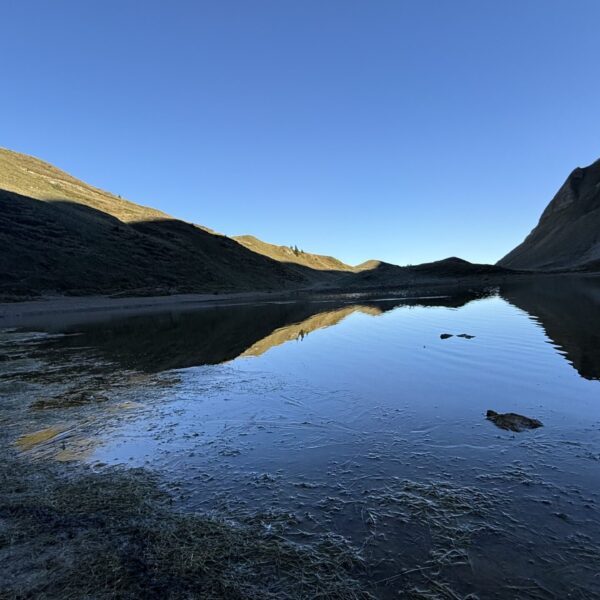 Eisee im Abendlicht: Spiegelung von Bergen in ruhigem Bergsee