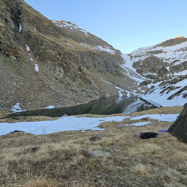 Zelten am Lagh de Calvaresc mit schneebedeckten Bergen