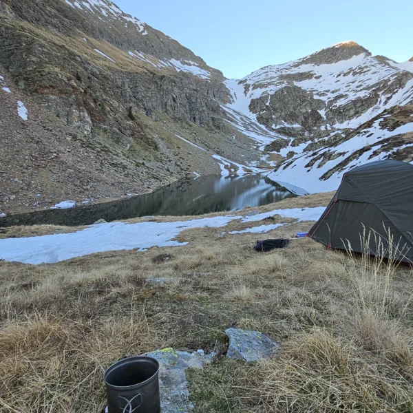 Zeltlager am Bergsee Lagh de Calvaresc mit Kochgeschirr im Vordergrund