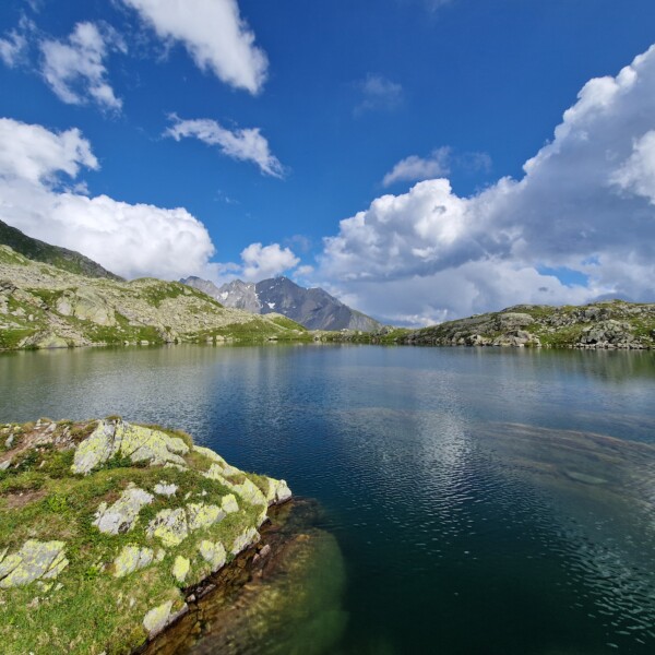 Lai Blau (Medel) Bergsee mit blauem Himmel und Wolken.