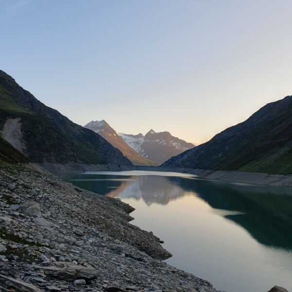 Lai da Curnera: Ruhiger Bergsee mit Spiegelung der schneebedeckten Gipfel.