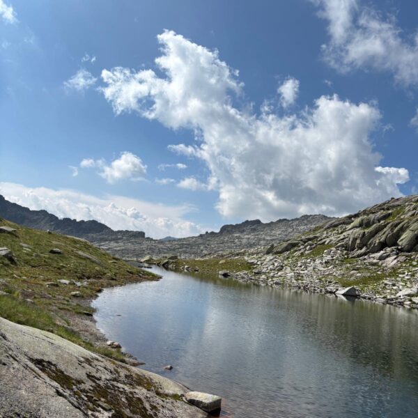 Langsee: Bergsee mit Felsen und Wolken am Himmel