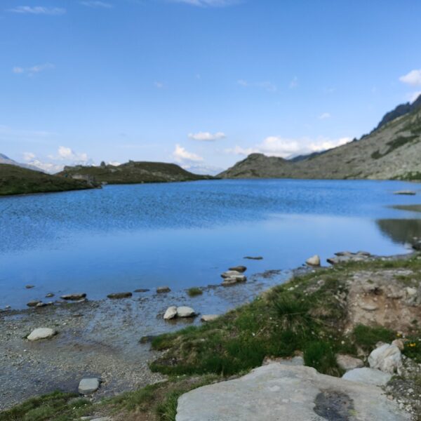 Lutersee bei Andermatt: Blauer Bergsee mit grünen Ufern und Felsen