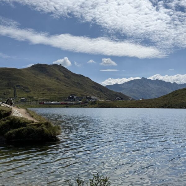 Oberalpsee mit Bergen und blauem Himmel im Hintergrund