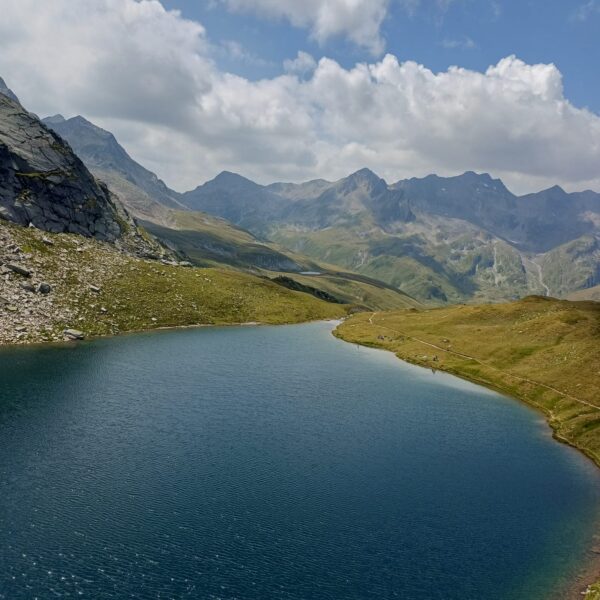 Portgerensee: Blauer Bergsee mit grünen Hängen und Wolken