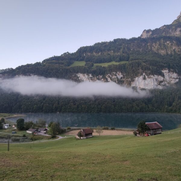 Seelisbergsee mit Nebelschwaden und Bergkulisse
