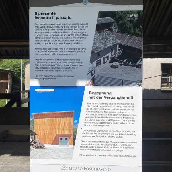 Ein zweisprachiges Informationsschild im Museo Poschiavino enthält italienischen und deutschen Text mit Fotos einer alten Mühle und eines modernen Gebäudes und beschreibt die Geschichte und Bedeutung des Museums.
