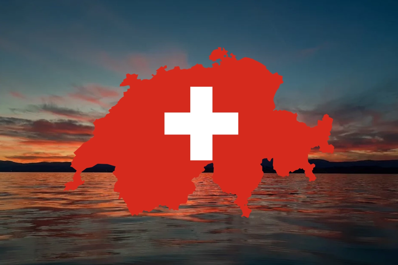 Eine rote Silhouette der Schweiz mit einem weißen Kreuz in der Mitte ist über eine im Sonnenuntergang beleuchtete See- und Berglandschaft gelegt.