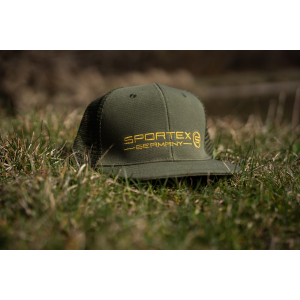 Eine olivgrüne Sportex Snap Cap Mesh 6 Panel // Stick mit gelbem "Sportex Germany"-Schriftzug und -Logo sitzt im Freien auf Gras vor einem sanft verschwommenen Naturhintergrund.