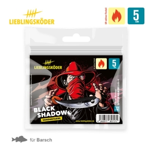 Eine "Black Shadow 5cm"-Verpackung zeigt eine Figur mit rotem Hut und Maske, die einen fischförmigen Köder hält. Piktogramme heben seine Verwendung für das Angeln auf Barsch und in warmen Gewässern hervor.
