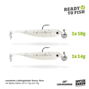 Das Actionpack Sunny 10cm enthält zwei weiße Weichplastikköder (10cm) mit Haken und runden Bleiköpfen (1x10g, 1x14g), beschriftet mit "Ready to Fish" und den Logos von Lieblingsköder und Spitze Haken.