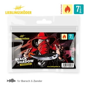 Die Köderverpackung "Black Shadow 7,5cm" von Lieblingsköder zeigt eine Hut tragende Figur mit rotem Halstuch, die den Köder hält. Icons unterstreichen seine Eignung für Barsch und Zander und zeigen an, dass er perfekt für warmes Wasser ist.