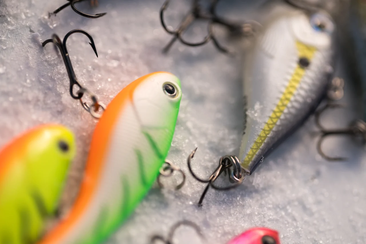 Bunte Hardbaits mit Haken auf Eis, passend zum Artikel "Richtig führen: 5 Techniken für mehr Erfolg mit Hardbaits
