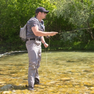 Mann beim Fliegenfischen im Fluss. Pro Shorty Wathose hüfthoch, Grösse S ist eventuell sichtbar.