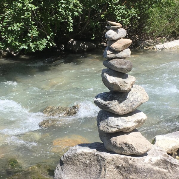 Steinturm am Flussufer, gestapelte Felsen. Binna.
