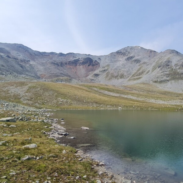 Illsee: Bergsee mit felsigen Ufern und Bergen im Hintergrund.