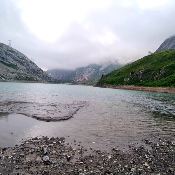 Sanetschsee: Trübes Wasser und Berge an einem bewölkten Tag.