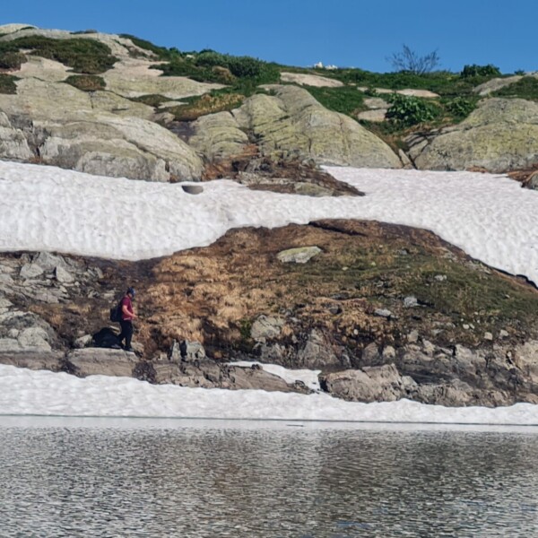 Totensee-Landschaft mit Schnee, Felsen und Personen am Ufer.