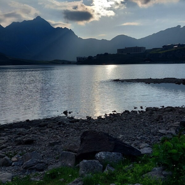 Melchsee: Bergsee mit Bergen und Wolken im Gegenlicht.