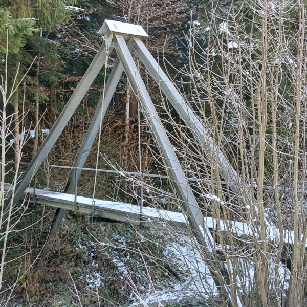Brücke in Buechwigger mit Schnee, umgeben von Bäumen.
