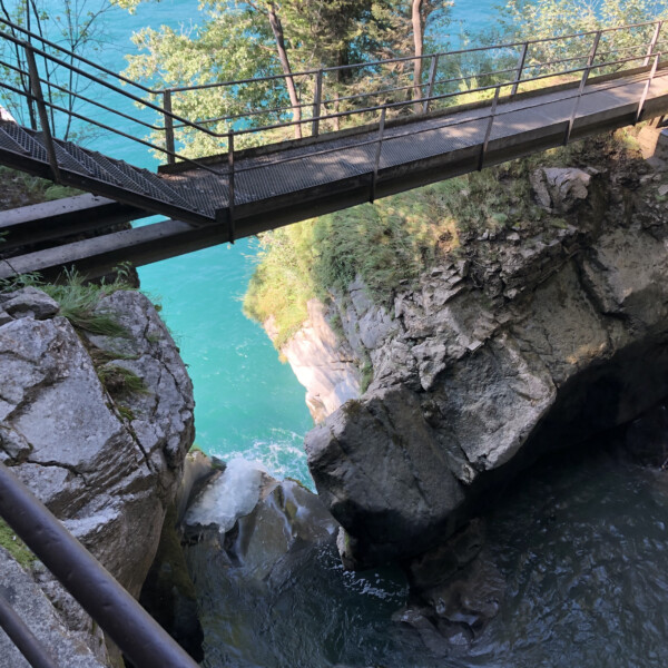Metallbrücke über türkisfarbenen Choltalbach in Emmetten, Schweiz.