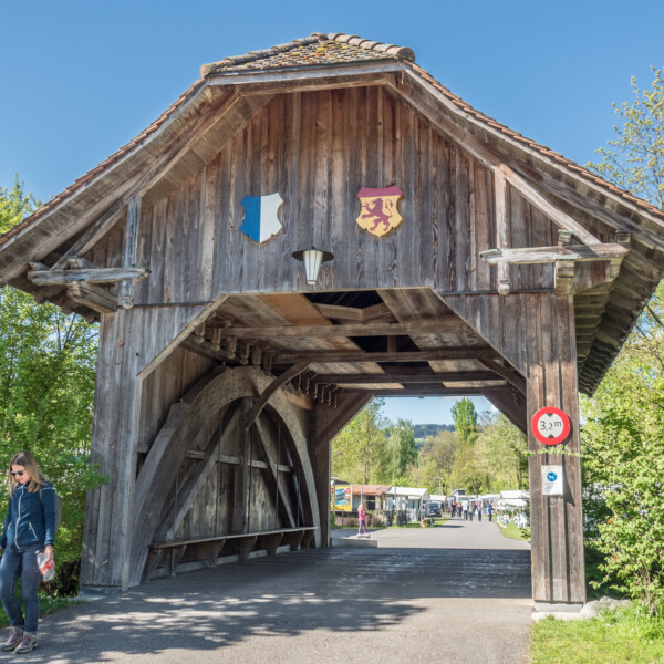 Historische Holzbrücke über die Grosse Aa mit Wappen und Höhenbeschränkung.