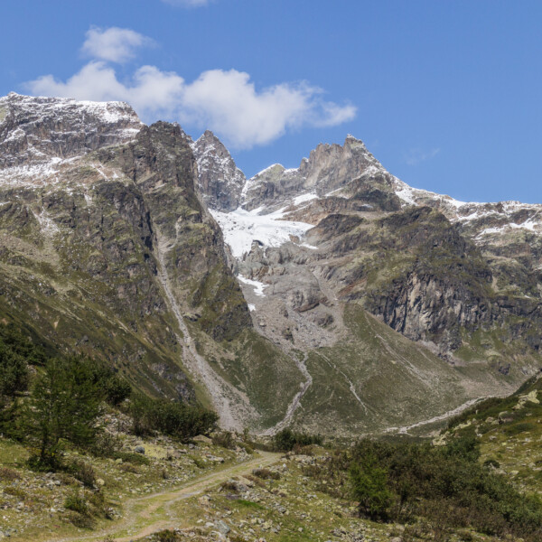 Berglandschaft mit Schnee und einem Pfad im Lavinuoz-Gebiet.
