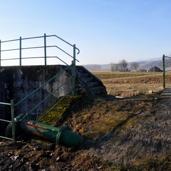 Grüne Geländer und Treppe über einen Kanal auf dem Land.