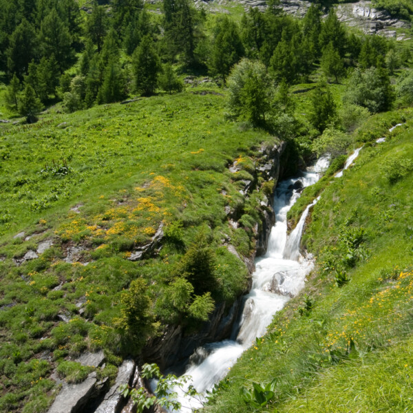 Wasserfall in Salentse, umgeben von grüner Landschaft und Felsen.