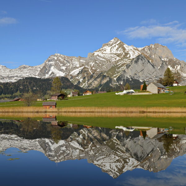 Schwendisee Spiegelung mit Bergen und Häusern. Idyllische Schweizer Landschaft.