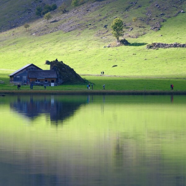 Seealpsee: Spiegelung eines Hauses im ruhigen Alpsee in den Schweizer Alpen.