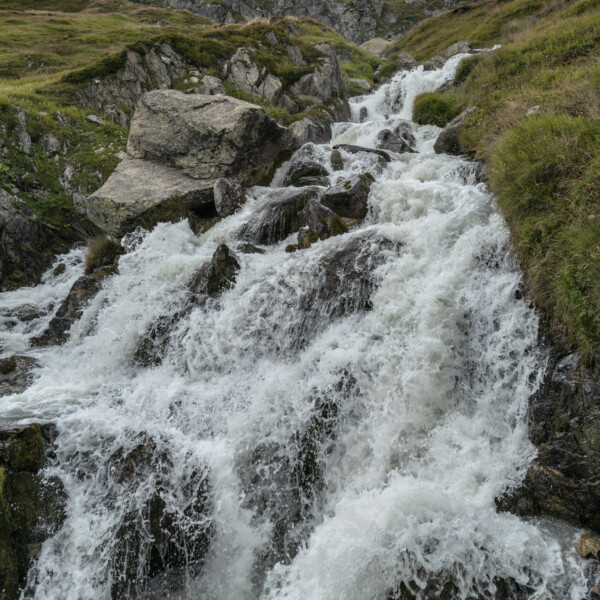 Sidelenbach: Tosender Wasserfall in den Schweizer Alpen mit Felsen und grüner Vegetation.