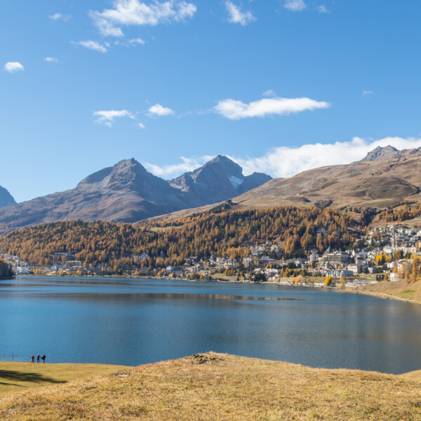 St. Moritzersee mit Bergen und Herbstlandschaft unter blauem Himmel