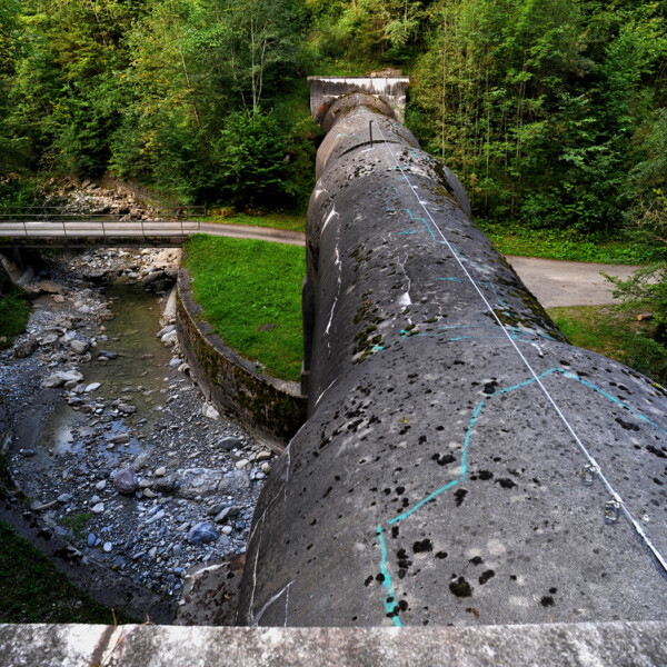 Trepsenbach: Betonrohr über Bachbett mit Brücke und üppigem Grün.