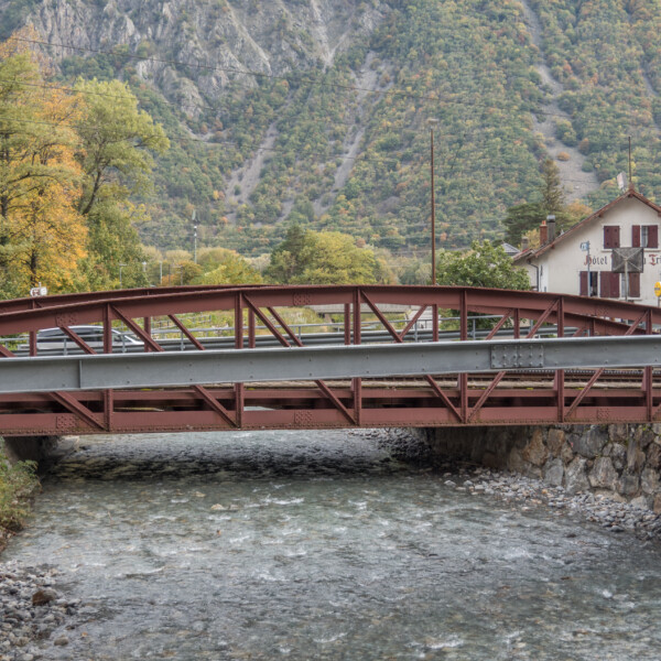 Brücke in Trient, Schweiz, über einen Fluss mit dem Hotel Trient im Hintergrund.