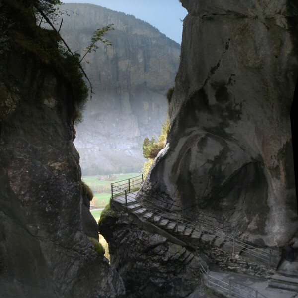 Trümmelbachfälle: Steg durch enge Felsschlucht mit Wasserfall und Felsen.