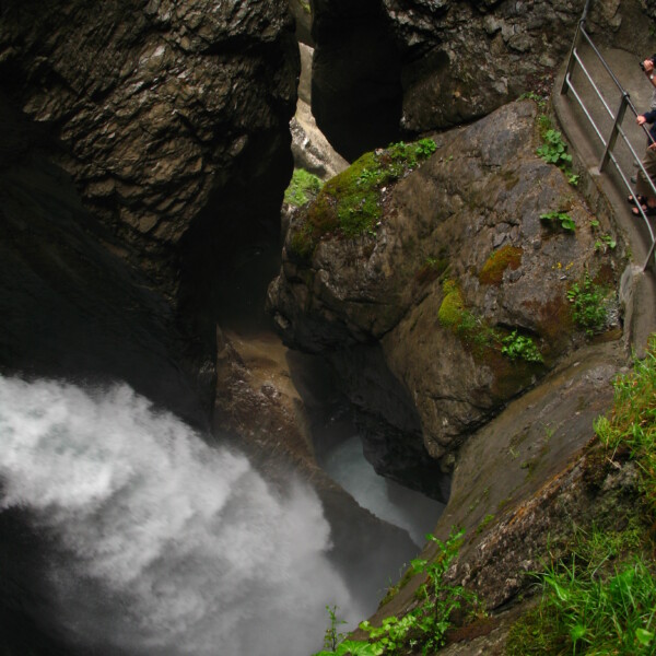 Trümmelbachfälle: Wasserfall in einer engen Schlucht mit Felsen und Treppe.
