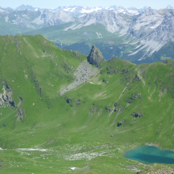 Grüne Berge und der Urdensee, ein Bergsee in den Alpen.
