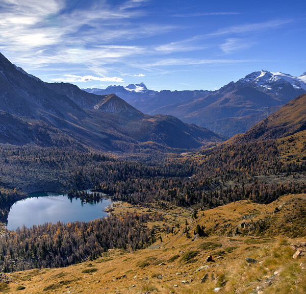 Bergsee im Val da Camp, Graubünden. Herbstliche Landschaft mit Bergen und blauem Himmel.