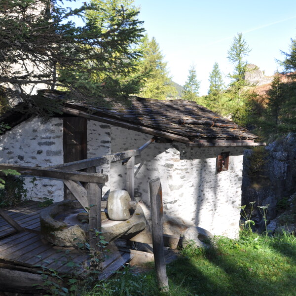 Alte Wassermühle in Valsorey, eingebettet in grüne Natur. Rustikales Gebäude mit Holzdetails.