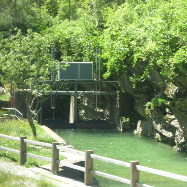 Wasserkraftanlage am Flussufer mit üppiger Vegetation. Varunasch.