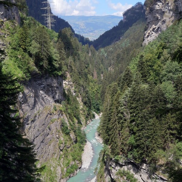 Albula: Schlucht mit türkisfarbenem Fluss, umgeben von grünen Bäumen und Felsen.