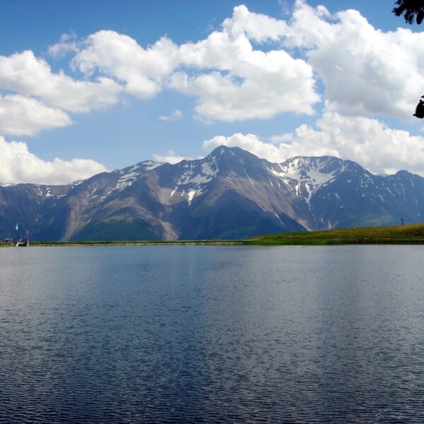 Bettmersee See mit Bergen und Wolken im Hintergrund
