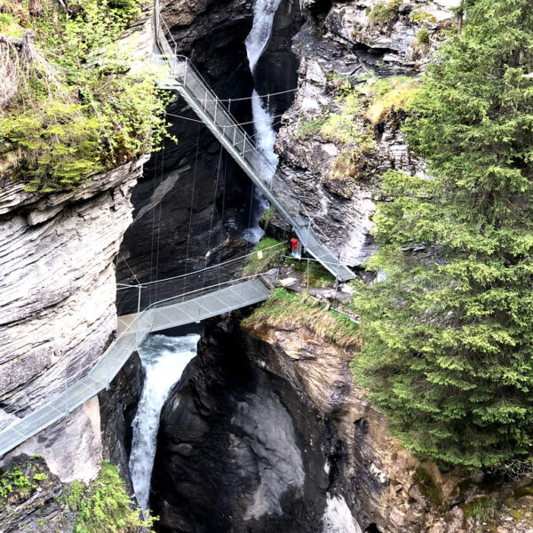 Hängebrücke über die Dala-Schlucht mit Wasserfall in Leukerbad, Schweiz.