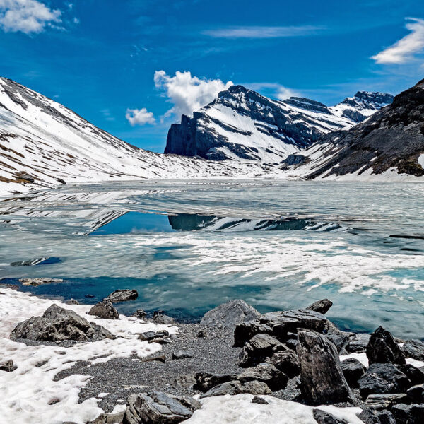 Gefrorener Daubensee in den Schweizer Alpen unter blauem Himmel.