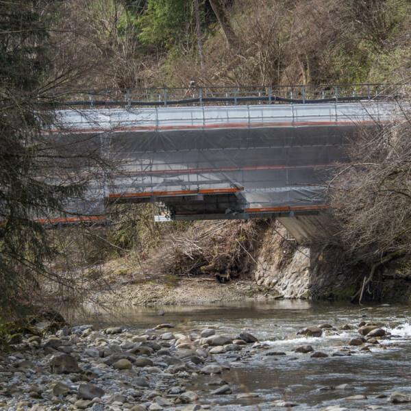 Brücke über Entlen Fluss im Bau, mit Gerüst und Plane verdeckt.