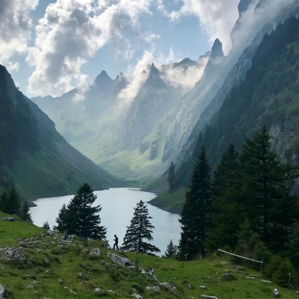 Fälensee: Malerischer Bergsee in den Schweizer Alpen mit Wanderer und dramatischen Wolken.