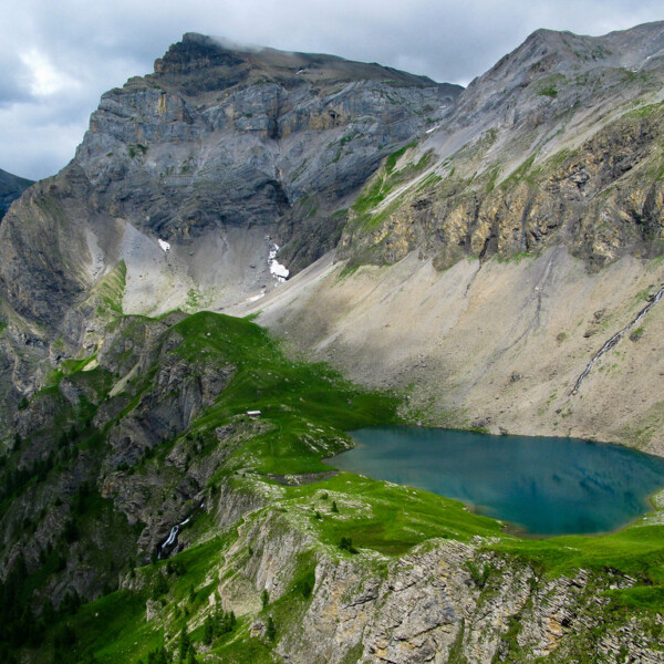 Flueseeli: Bergsee in den Schweizer Alpen mit grünen Wiesen und felsigen Gipfeln.
