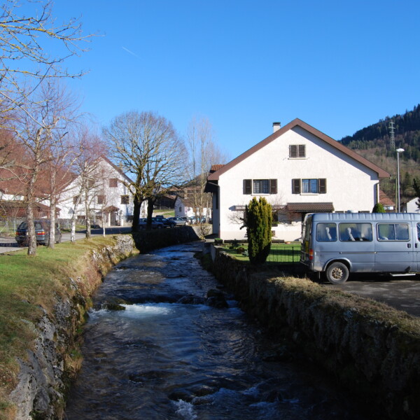 Fluss Gabiare fliesst durch ein malerisches Dorf mit Häusern und einem silbernen Van.