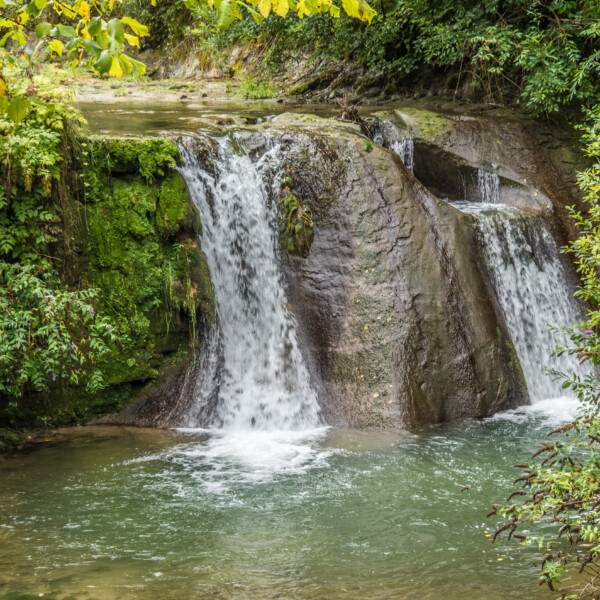 Wasserfall in Galtera (Gottéron) mit grüner Vegetation und Felsen